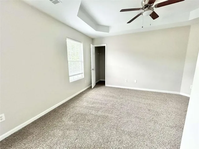an empty room with a ceiling fan and window