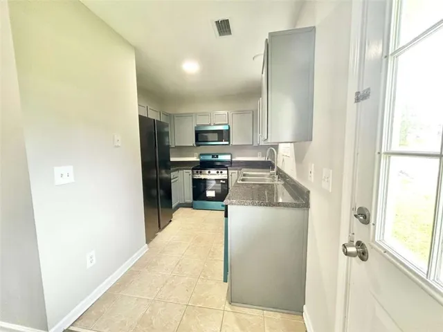 a kitchen with stainless steel appliances granite countertop a refrigerator and a stove top oven