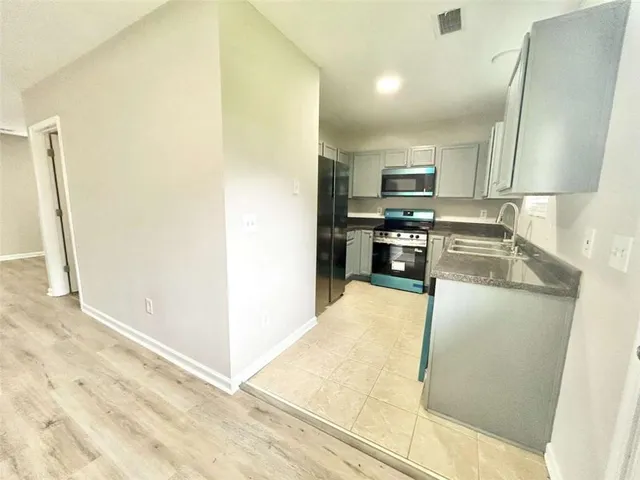 a kitchen with stainless steel appliances granite countertop a refrigerator and a stove
