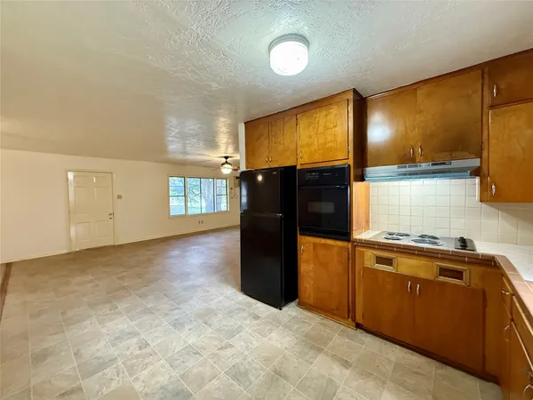a kitchen with stainless steel appliances granite countertop a refrigerator and a stove top oven