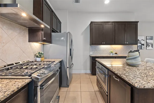 a kitchen with granite countertop a stove sink and cabinets