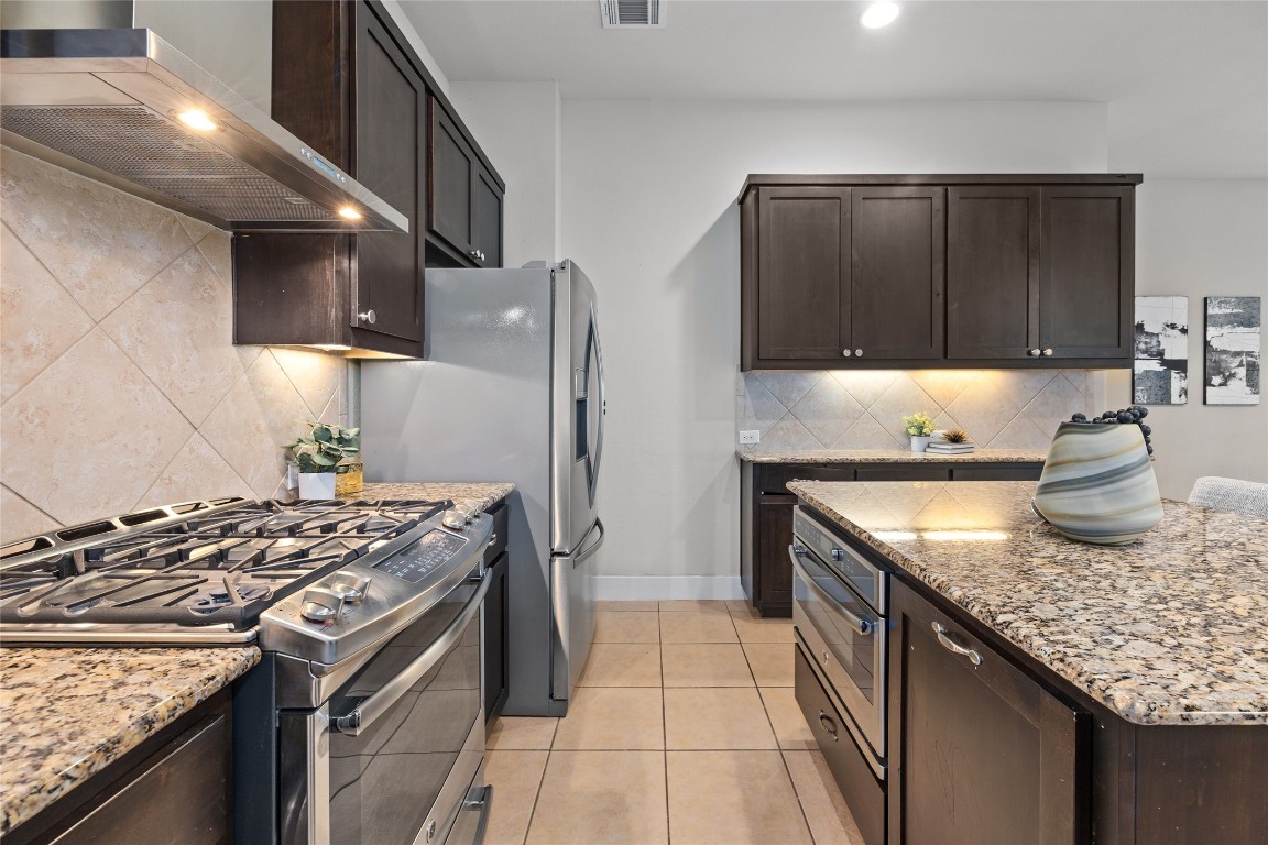 405 Penny Kathleen Court Austin, TX 78717 - Photo 12 of 30 a kitchen with granite countertop a stove sink and cabinets