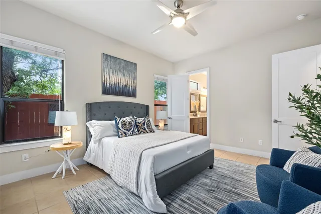 a bedroom with a large bed couch and windows