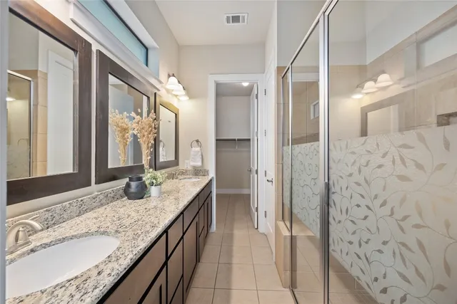 a bathroom with a granite countertop sink a mirror and a shower