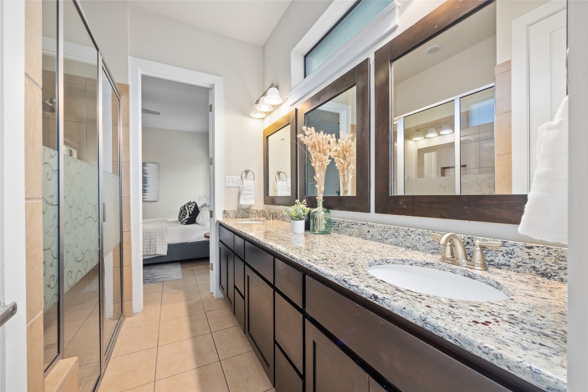 405 Penny Kathleen Court Austin, TX 78717 - Photo 21 of 30 a en suite bathroom with a granite countertop sink and a mirror