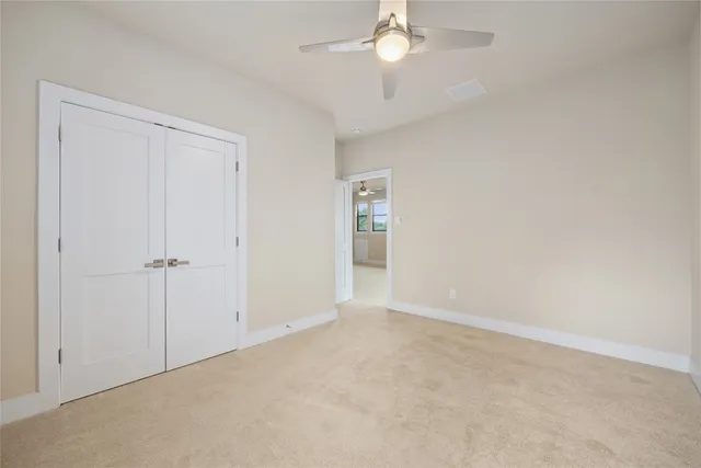 an empty room with a ceiling fan and a window