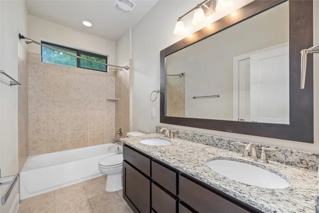 a bathroom with a granite countertop tub sink and mirror