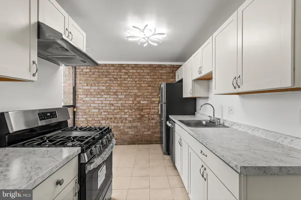 a kitchen with a sink stove top oven and cabinets