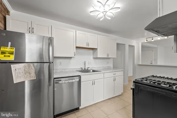 a kitchen with stainless steel appliances granite countertop a stove a refrigerator and a sink