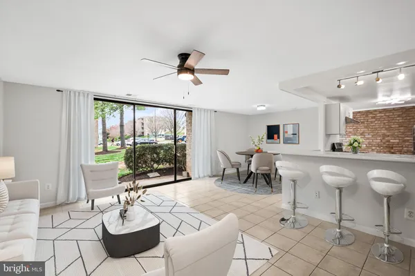 a living room with furniture a flat screen tv and a large window