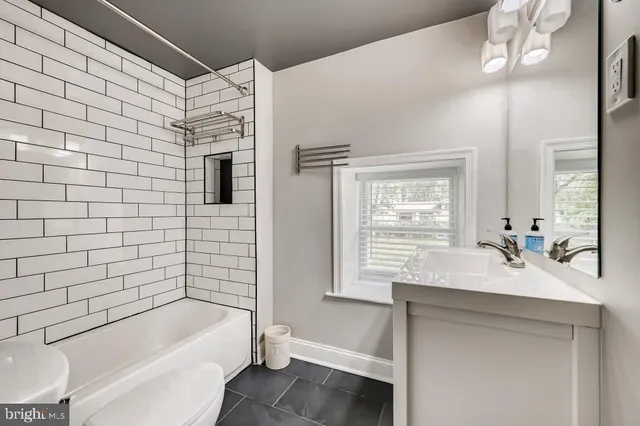 a bathroom with a tub sink and mirror