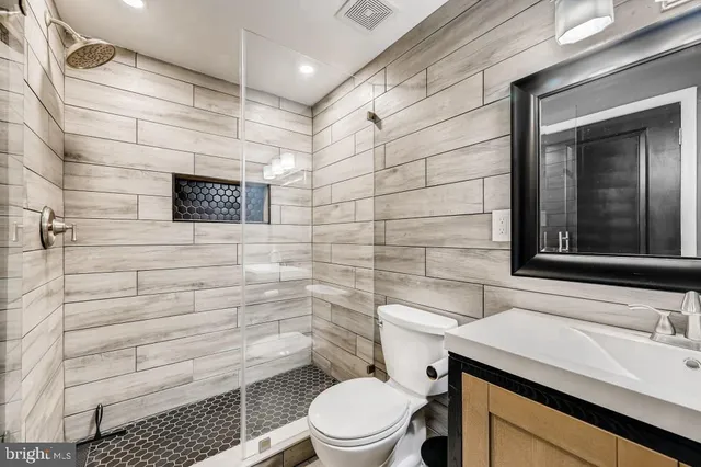 a bathroom with a sink a toilet and shower
