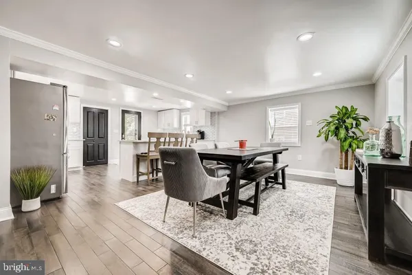 a dining room with furniture potted plants and wooden floor