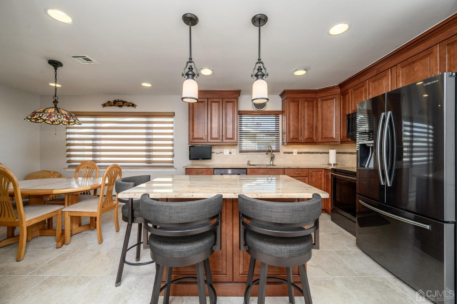 3 Bow Drive Brick, NJ 08723 - Photo 11 of 36 a kitchen with stainless steel appliances a table chairs and refrigerator
