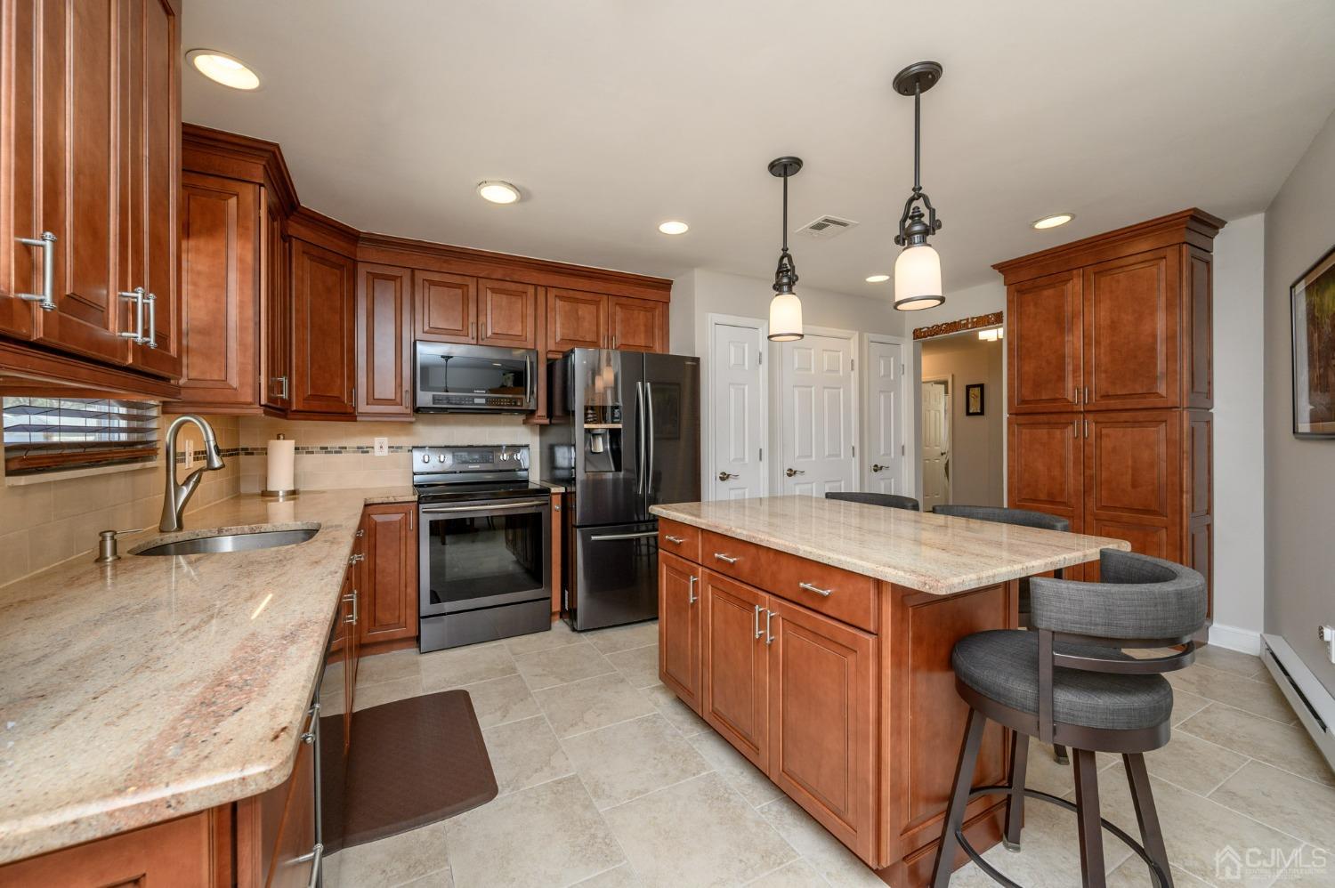 3 Bow Drive Brick, NJ 08723 - Photo 12 of 36 a kitchen with a refrigerator a sink a stove and chairs