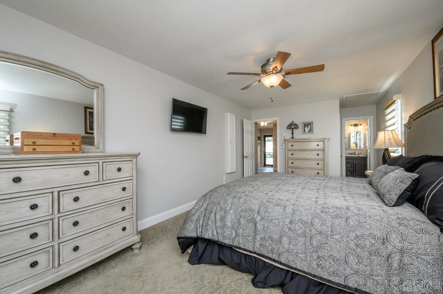 3 Bow Drive Brick, NJ 08723 - Photo 19 of 36 a bedroom with a large bed a flat tv screen on dresser and a chandelier