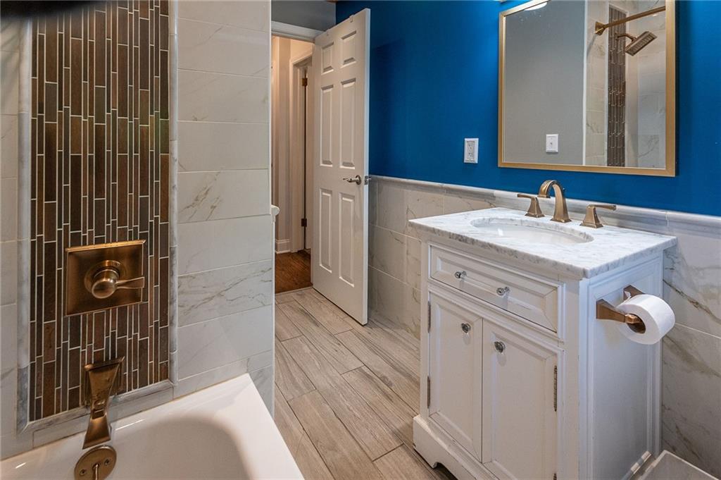 357 Carley Avenue Sharon, PA 16146 - Photo 20 of 32 a bathroom with a granite countertop sink a mirror and shower