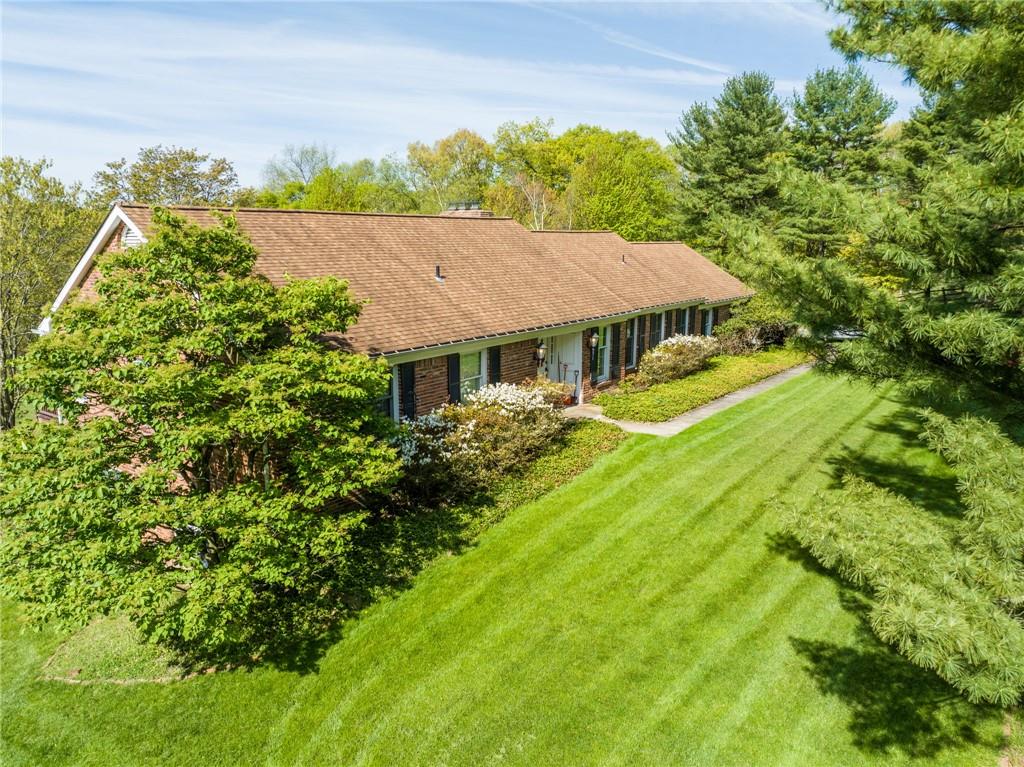 a view of a house with a big yard plants and large trees