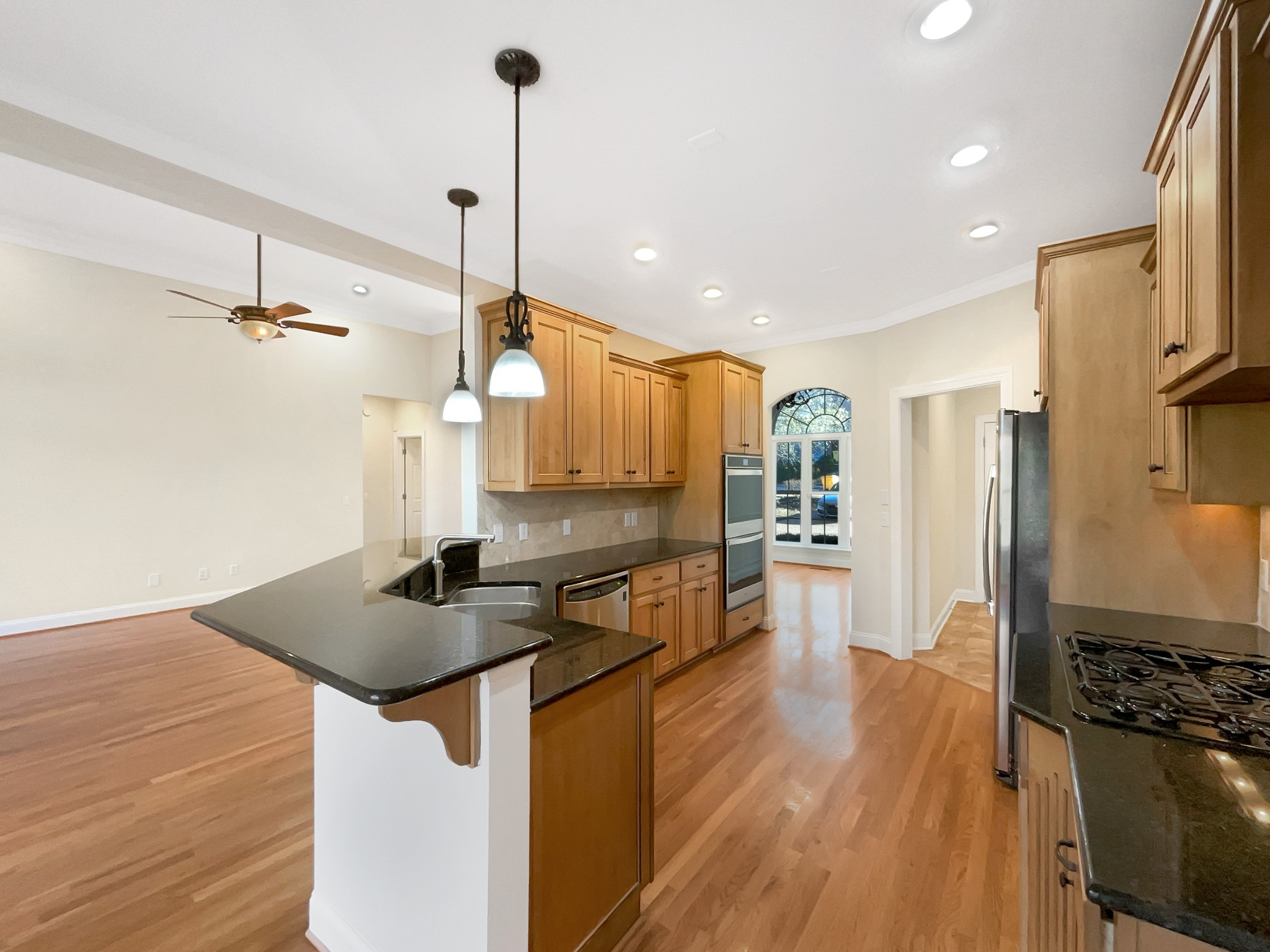 7302 Kempton Court Fairview, TN 37062 - Photo 7 of 28 a kitchen with stainless steel appliances granite countertop a sink a stove and a wooden floor