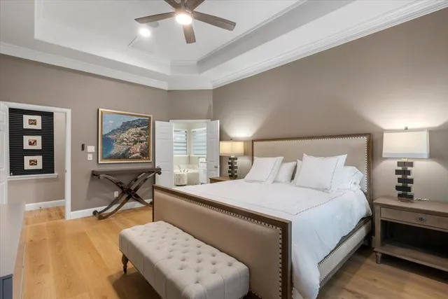 a bedroom with a bed a table and painting on the wall