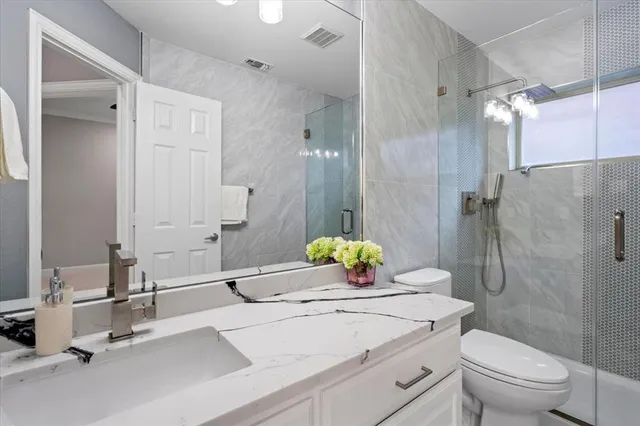 a bathroom with a sink toilet vanity and shower