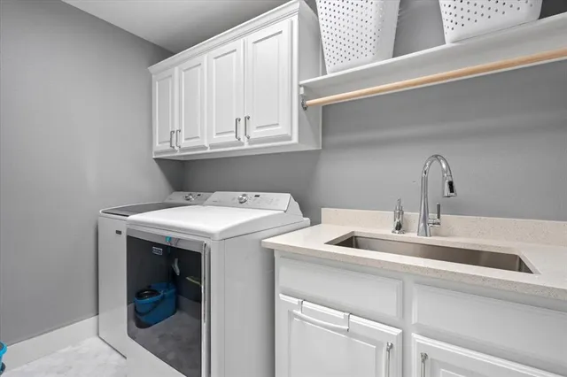 a utility room with sink dryer and washer
