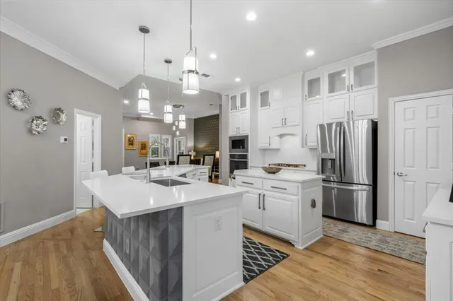 a kitchen with kitchen island a sink stainless steel appliances and cabinets