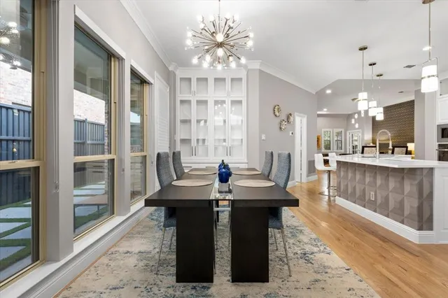 a kitchen island with granite countertop a sink dishwasher a dining table and chairs with wooden floor