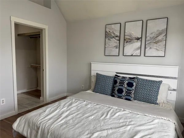 a bedroom with a bed and painting on the wall