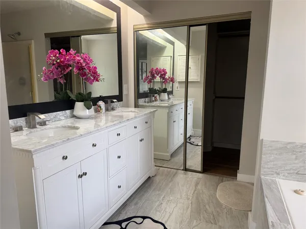 a bathroom with a sink vanity and mirror
