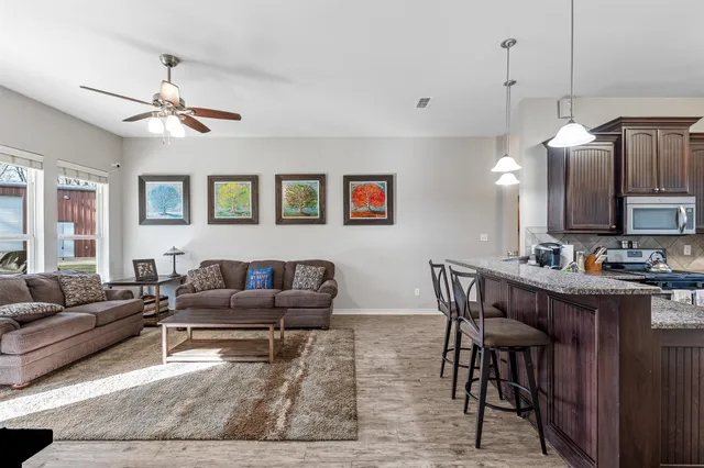 a living room with furniture kitchen view and a chandelier