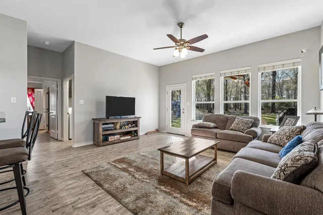 a living room with furniture and a flat screen tv with wooden floor