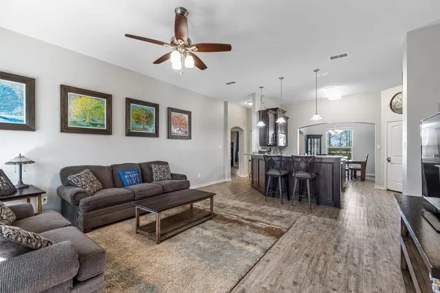a living room with furniture and a wooden floor