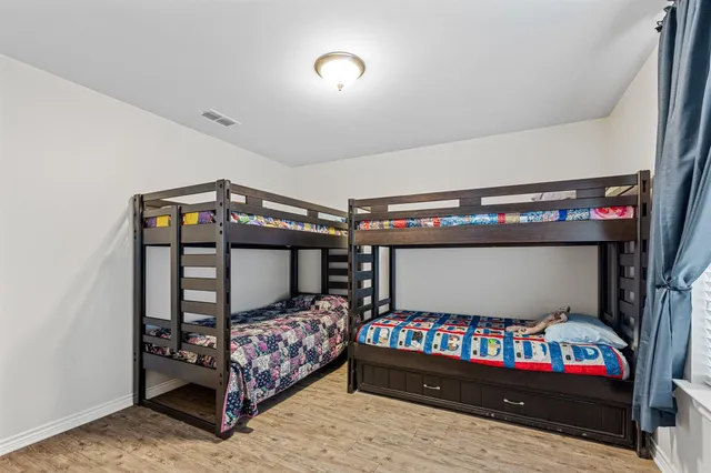 a bedroom with a bed and a wooden floor