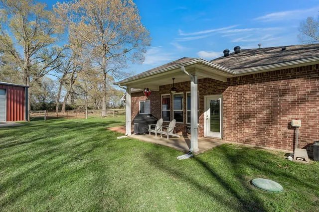 a view of a chair and table in backyard of the house