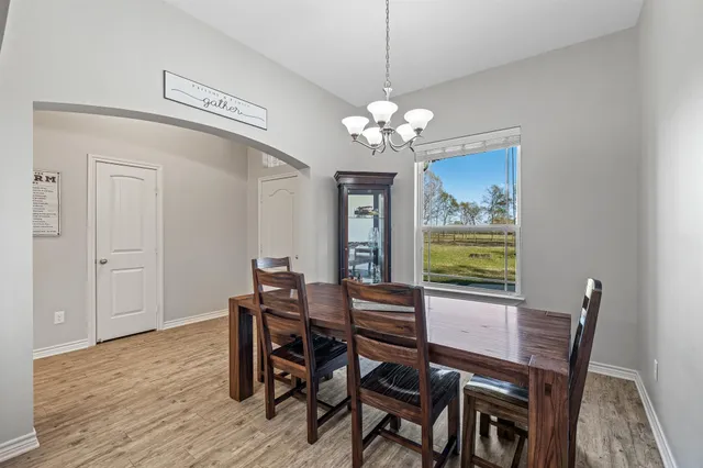 a view of a dining room with furniture a chandelier and wooden floor