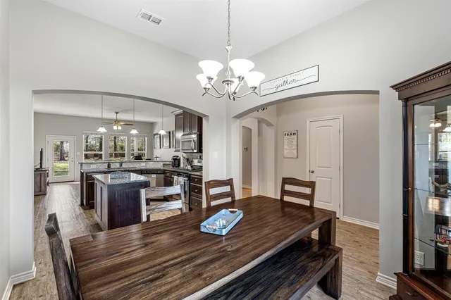 a view of a dining room with furniture a chandelier and wooden floor
