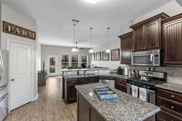 a kitchen with granite countertop lots of counter top space and stainless steel appliances