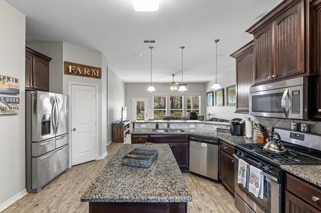 a kitchen with stainless steel appliances granite countertop a sink stove and refrigerator
