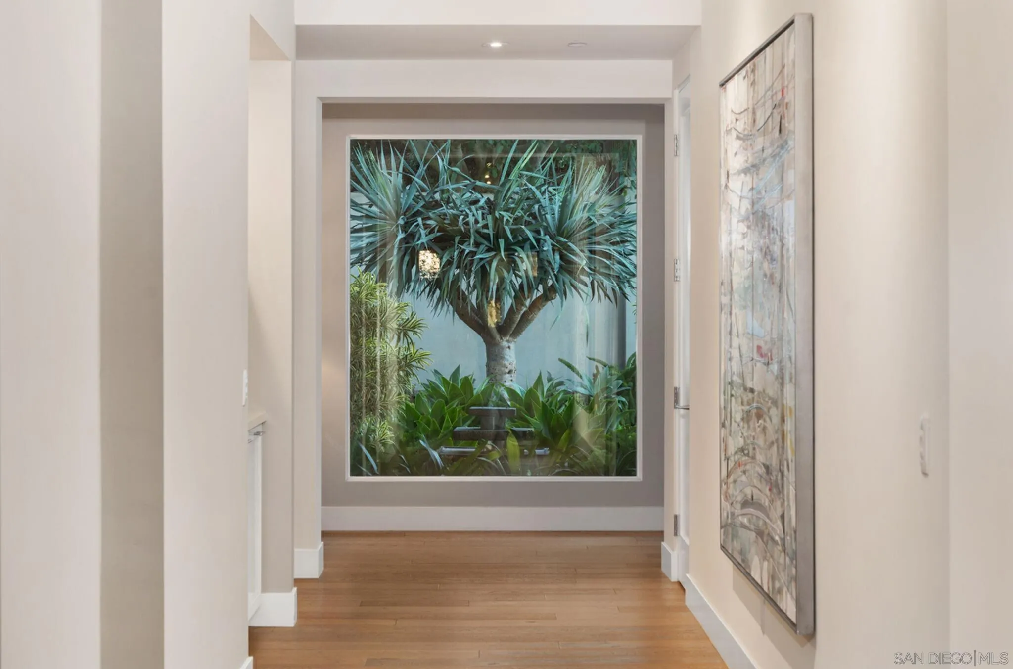6968 St Andrews Road Rancho Santa Fe, CA 92067 - Photo 16 of 23 downstairs hallway. Every window and door you look out is beautiful. The landscape lighting brings the outdoors to life in the evening.