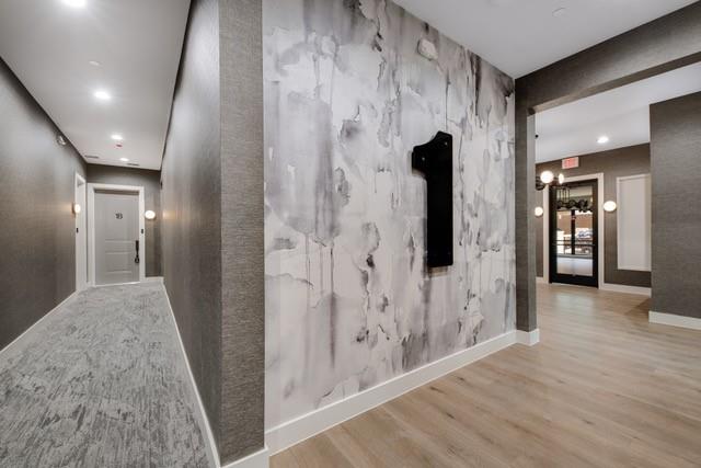 3601 Routh Street, Unit 2E Dallas, TX 75219 - Photo 13 of 14 Hall featuring baseboards, a notable chandelier, and wood finished floors
