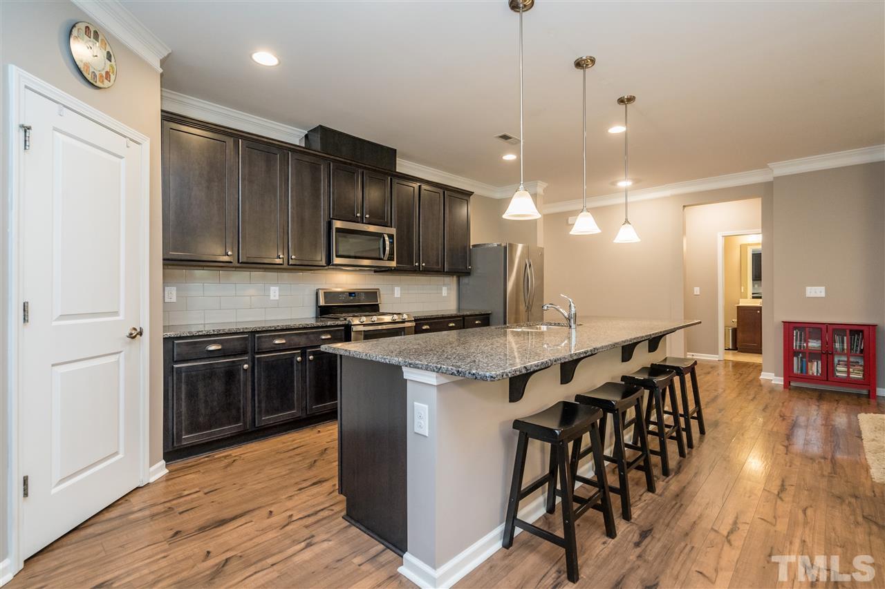 439 Plainview Avenue Raleigh, NC 27604 - Photo 7 of 29 a kitchen with stainless steel appliances granite countertop a stove top oven a sink dishwasher a dining table and chairs with wooden floor