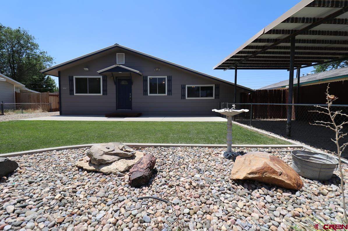 771 Aspen Drive Cortez, CO 81321 - Photo 27 of 36 a view of a backyard with a table and chair under an umbrella