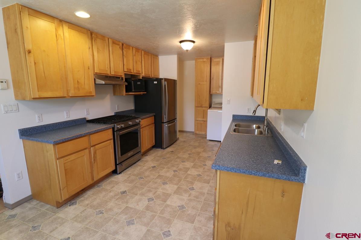 771 Aspen Drive Cortez, CO 81321 - Photo 10 of 36 a kitchen with a sink a refrigerator and cabinets