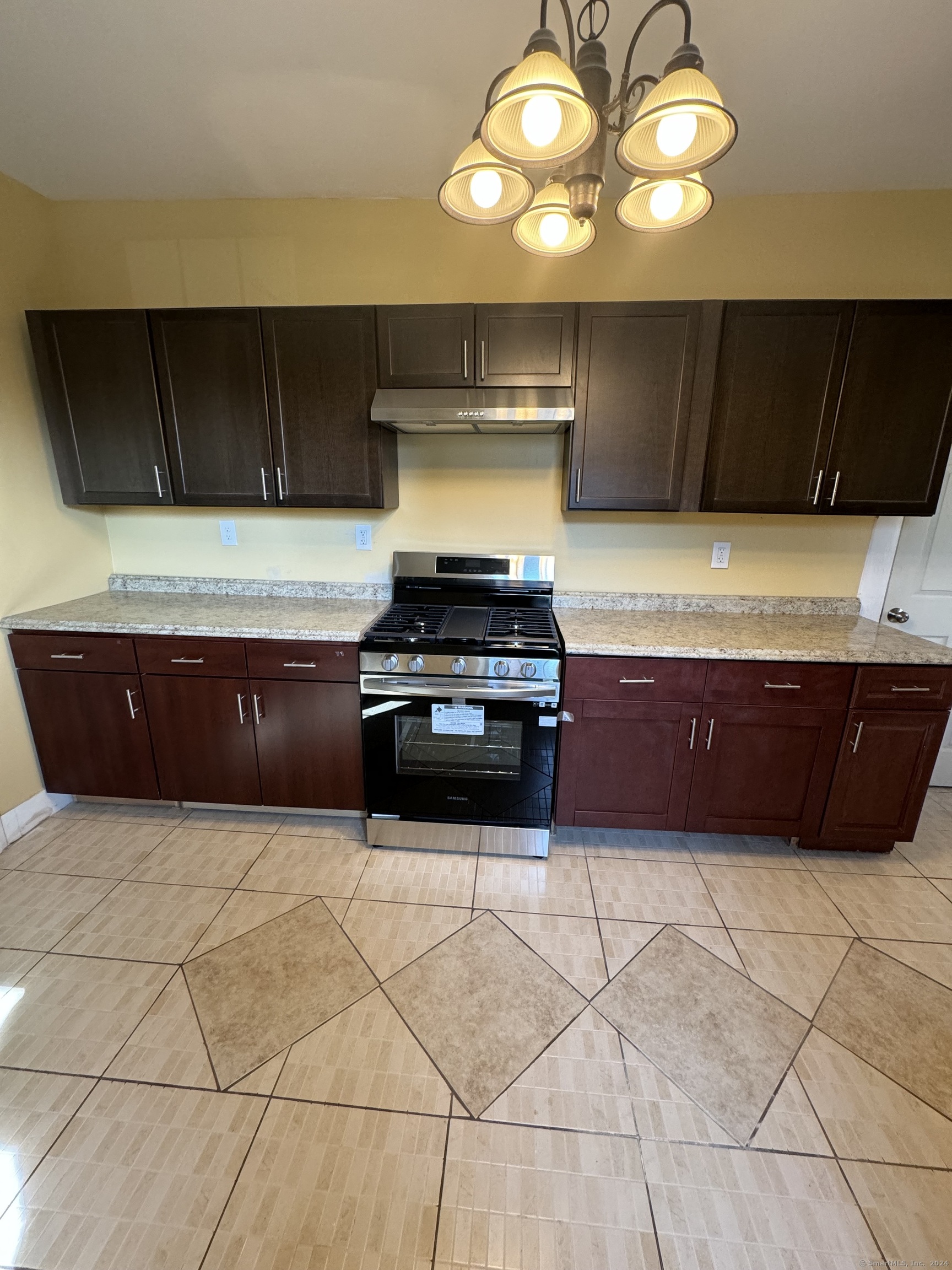 a kitchen with stainless steel appliances a cabinets and stove top oven