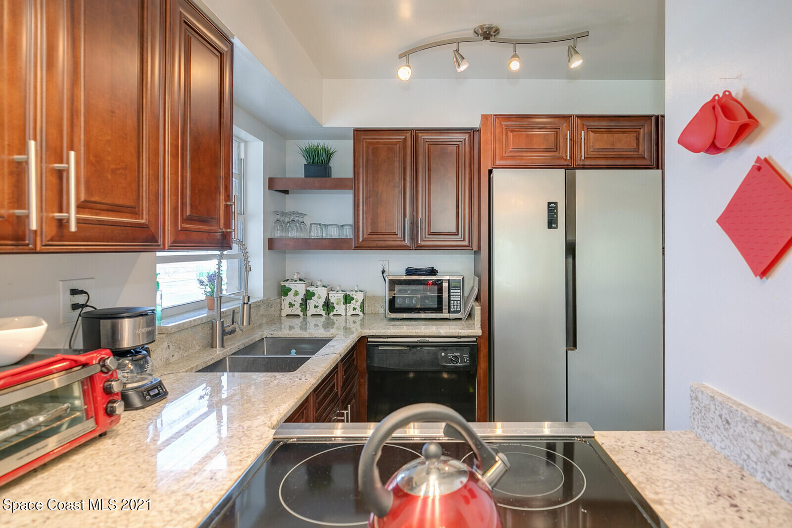 1225 North Wickham Road, Unit 416 Melbourne, FL 32935 - Photo 2 of 5 a kitchen with stainless steel appliances granite countertop a refrigerator and a sink