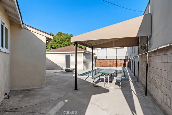 a view of a patio with table and chairs with wooden floor and fence