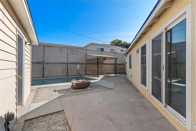 a view of a patio with table and chairs and wooden fence