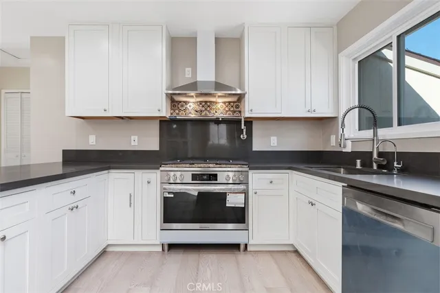 a kitchen with granite countertop white cabinets and white stainless steel appliances