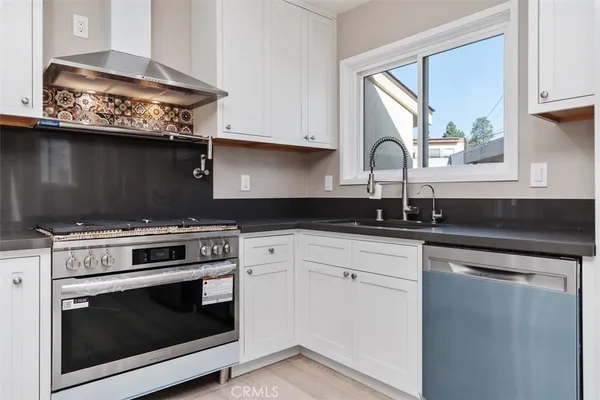 a kitchen with stainless steel appliances granite countertop a stove a sink and a microwave